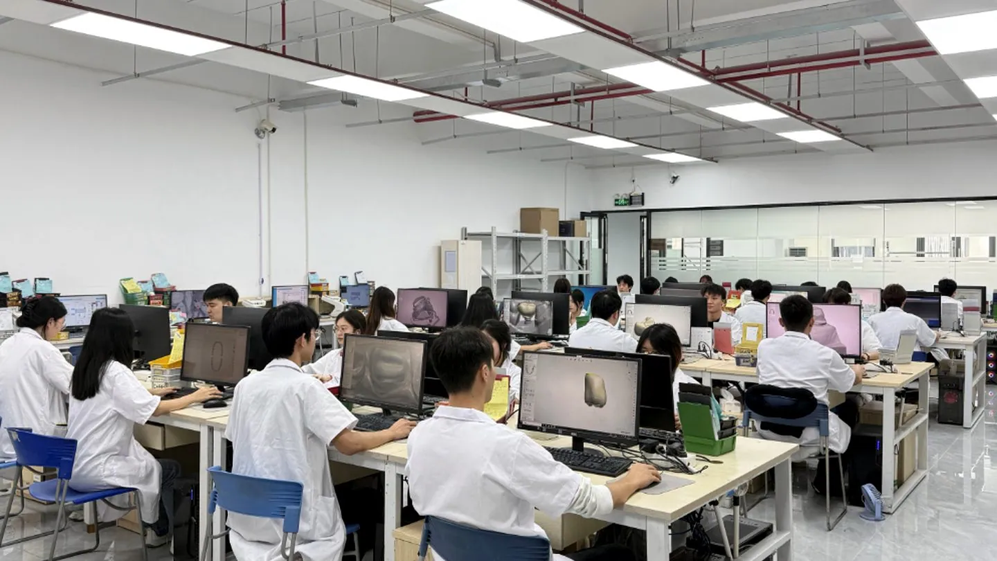 KC Dental Lab CAD design room — technicians designing restorations at workstations.